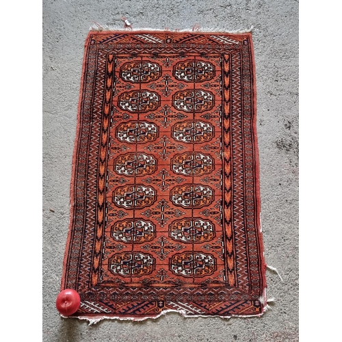 968 - A charming handwoven floor rug of Turkish origin. Designed in a rich orange colour with striking bla... 