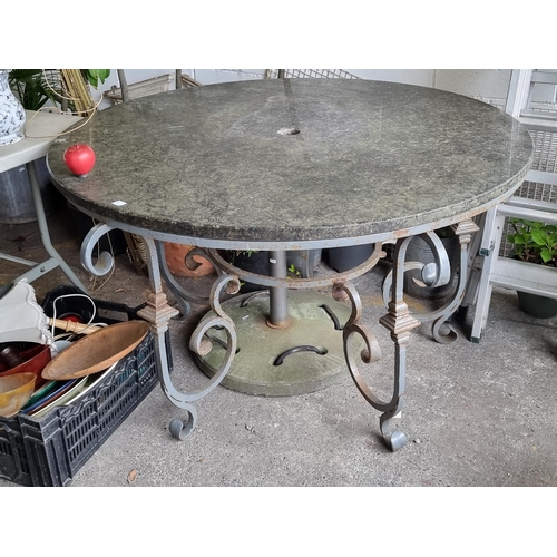 983 - Star Lot : A very heavy black marble garden table with a wrought metal base in a grey finish. With l... 