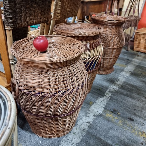 928 - Three large woven wicker baskets in an urn shape with lid to top. One features coloured red effect a... 