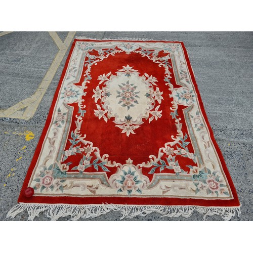 982 - A large thick pile vintage Chinese floor rug. Featuring as soft floral display in pastels with a str... 