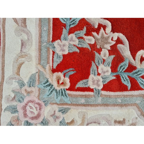 982 - A large thick pile vintage Chinese floor rug. Featuring as soft floral display in pastels with a str... 