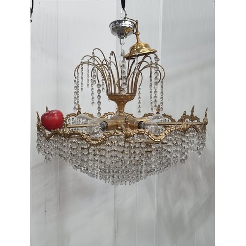 988 - An ornate tiered chandelier with beaded droplets throughout and brass toned frame with foliate detai... 