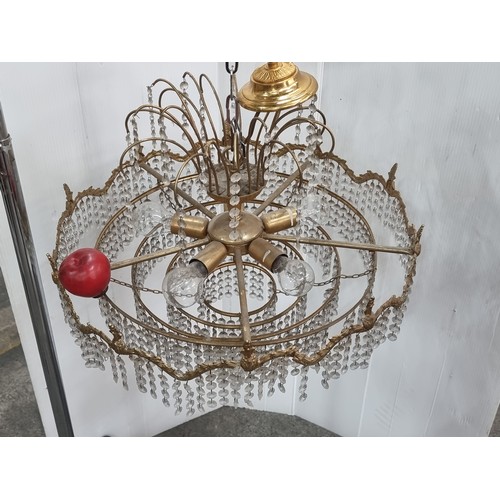 988 - An ornate tiered chandelier with beaded droplets throughout and brass toned frame with foliate detai... 