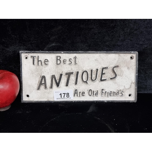 178 - A heavy  cast metal wall plaque reading 'The Best Antiques are Old Friends'.