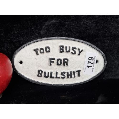 179 - A neatly proportioned oval heavy cast metal wall plaque with a humorous text in a black and white fi... 