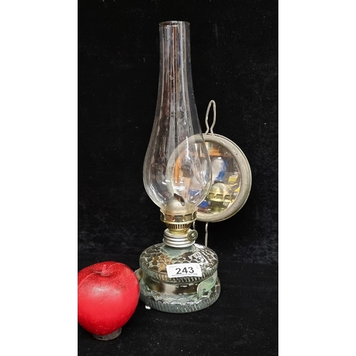 243 - A striking hand blown glass oil lamp with scalloped pattern to well, glass chimney and a mirrored ba... 