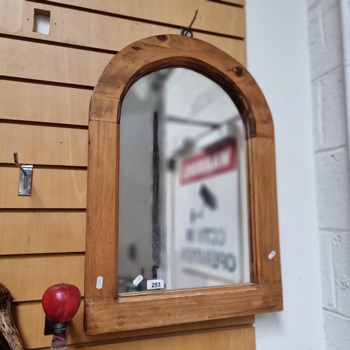 253 - An arched wall mirror with arched solid wood frame.