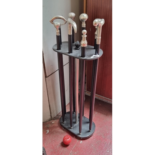 264 - Star Lot ; A nice quality walking stick stand with eight walking sticks within, each with silver ton... 