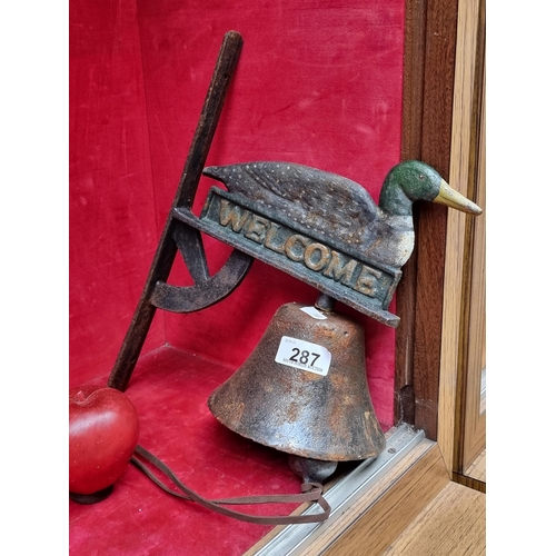 287 - A charming and very heavy cast metal bell in the form of a duck atop of a 'Welcome' sign. With a bra... 