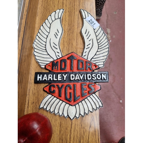 291 - A branded heavy cast metal wall plaque reading 'Harley Davidson Motor Cycles' and featuring a pair o... 