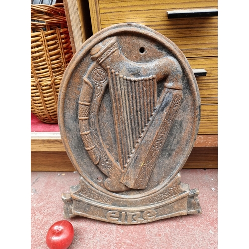 297 - An extremely heavy and large cast metal wall plaque depicting the Irish harp and reading 'Eire'.