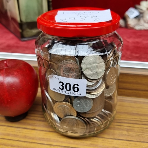 306 - A glass jar containing a large amount of vintage Irish.and Uk coinage unchecked