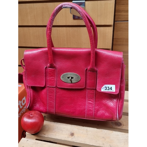 334 - Star lot : A beautiful genuine Mulberry ladies handbag in a hot pink shade with brass toned fittings... 