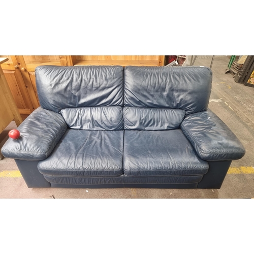 355 - A comfortable soft leather two-seater sofa with wide armrests in a deep blue finish. In nice conditi... 