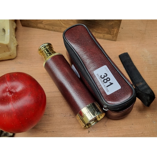 381 - A triple draw pocket telescope / spyglass. Crafted in a polished brass with a red leather cladding a... 