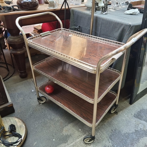 416 - A vintage drinks trolley with pierced gallery and removable top tier. Two further tiers below, set o... 