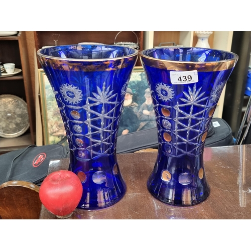 439 - A pair of vintage tall Bohemian style cut crystal vases in a vibrant shade of cobalt blue with gilde... 