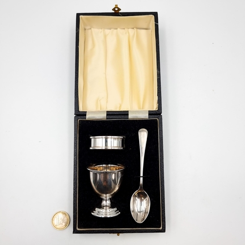 51 - A fabulous boxed silver collection, comprising of a sterling silver egg cup, spoon and napkin holder... 