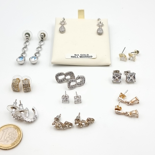 A large and assorted collection of sterling silver gem set stud earrings, in an array of styles of designs.
