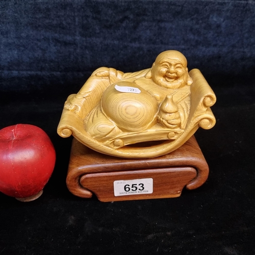 653 - A handcarved laughing Buddha. Designed in a lovely golden toned wood and featuring carved wood base ... 