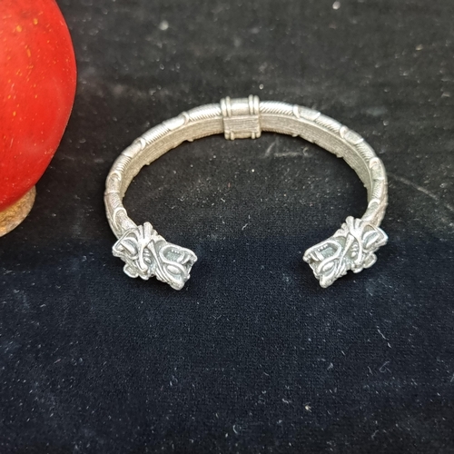 658 - A heavy Chinese bangle with figural dragon head finials.