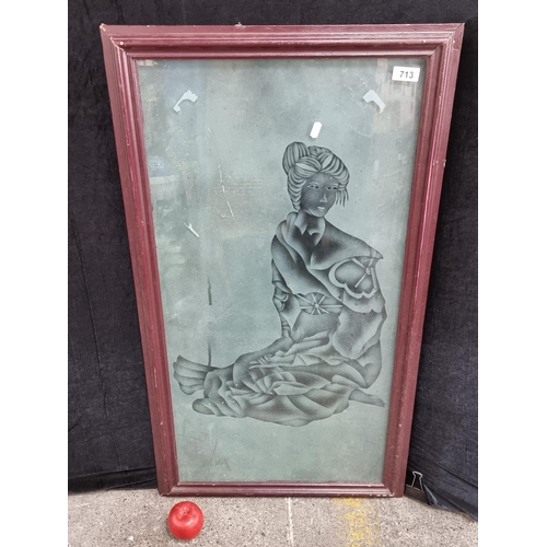 713 - A large heavy  panel of glass with frosted scene of a Chinese woman kneeling, held in a wooden frame... 