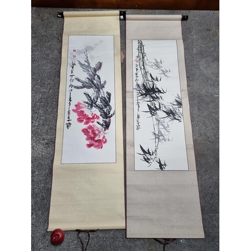 740 - A pair of handpainted Chinese ink on paper wall scroll hangings illustrated with large floral and fo... 