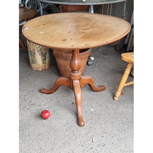 748 - A fabulous antique oak tilt top table. The oval top is supported by a turned pedestal leading to thr... 