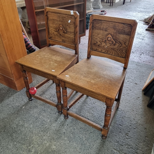 925 - A wonderfully crafted pair of arts and crafts ecclesiastical style golden oak chairs. With wide flar... 