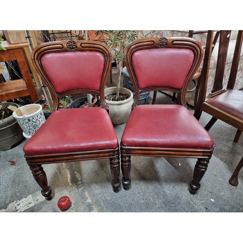 938 - A pair of Victorian mahogany dining chairs. Featuring nicely turned front legs and a burgundy red le... 