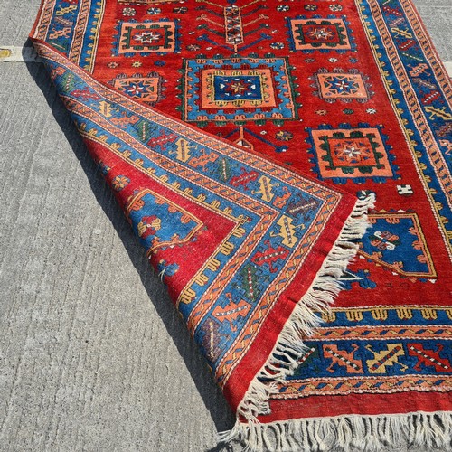 752 - Star lot : A beautiful  large handknotted wool rug. Designed in a rich palette of reds and blues wit... 