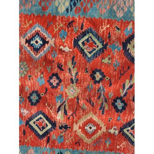 804 - A large Turkish rug in shades of red and blue and geometric design. With cream fringe L310cm x W200c... 