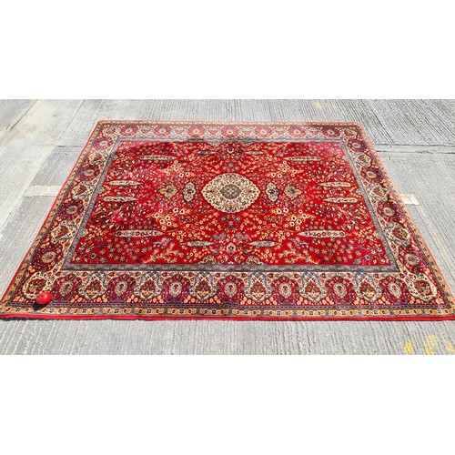 913 - A large vintage Indian floor rug. Designed in shades of red and gold with tree and floral motifs. L2... 