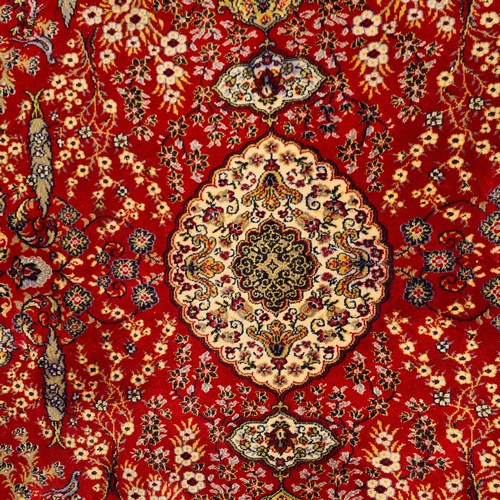 913 - A large vintage Indian floor rug. Designed in shades of red and gold with tree and floral motifs. L2... 