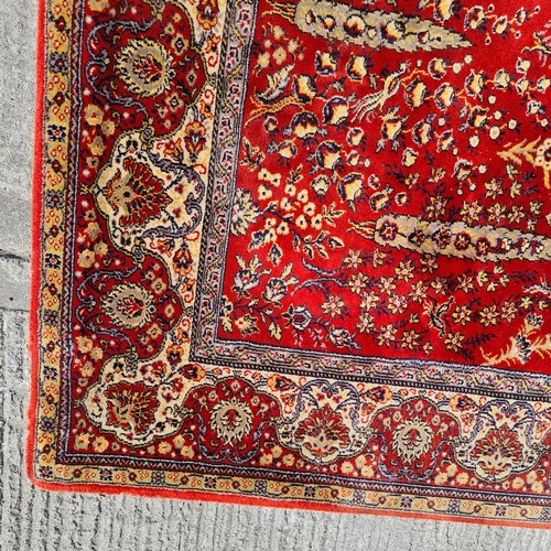 913 - A large vintage Indian floor rug. Designed in shades of red and gold with tree and floral motifs. L2... 