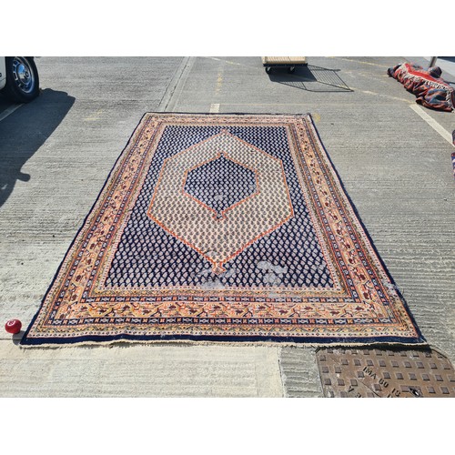 741 - A large hand knotted Persian rug in a blue and cream pattern with orange detailing. Some wear as pic... 