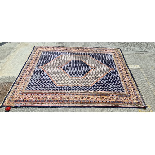 741 - A large hand knotted Persian rug in a blue and cream pattern with orange detailing. Some wear as pic... 