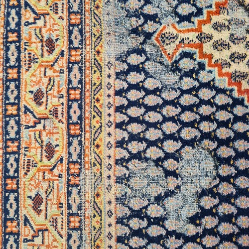 741 - A large hand knotted Persian rug in a blue and cream pattern with orange detailing. Some wear as pic... 