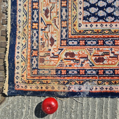 741 - A large hand knotted Persian rug in a blue and cream pattern with orange detailing. Some wear as pic... 