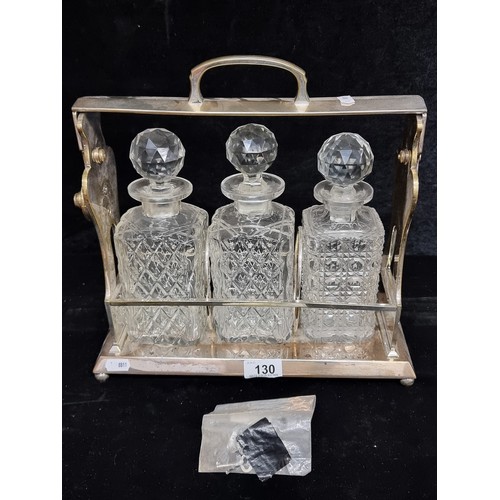 130 - Star Lot : A fantastic example of an antique Betjemann's tantalus holding three cut crystal decanter... 