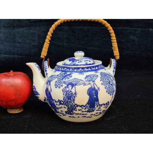 672 - A porcelain bachelor's teapot with a lovely blue glaze pattern of Japanese Geishas with parasols hel... 