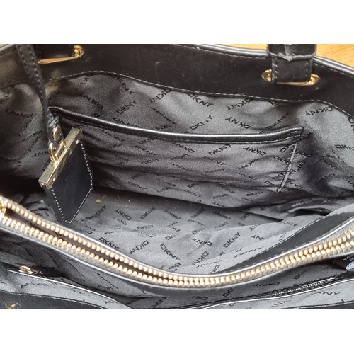 336 - A stylish DKNY black genuine leather with ample storage including zip up compartments to interior an... 