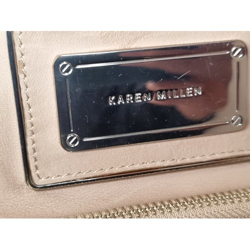 337 - A Karen Millen genuine leather bag with plenty of storage to front as well as interior in a light be... 