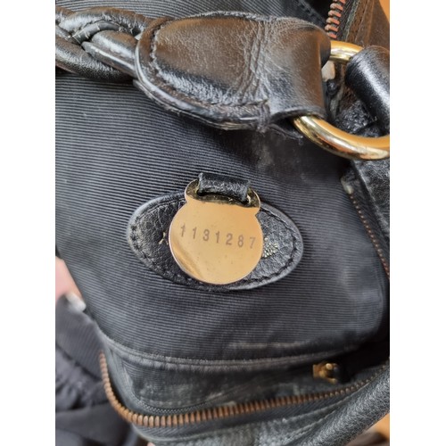 339 - A genuine ladies Mulbery black leather handbag with large metal emblem to front and a braided handle... 