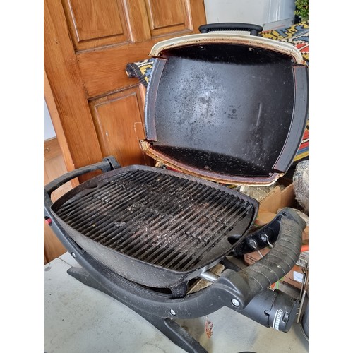 751 - A portable table top Webber barbeque, accompanied by two cans of propane gas. Webber is known for hi... 