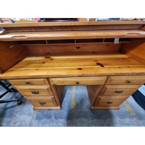 856 - A solid pine roll top desk with gallery back to top, three shelf compartments to back, along with se... 