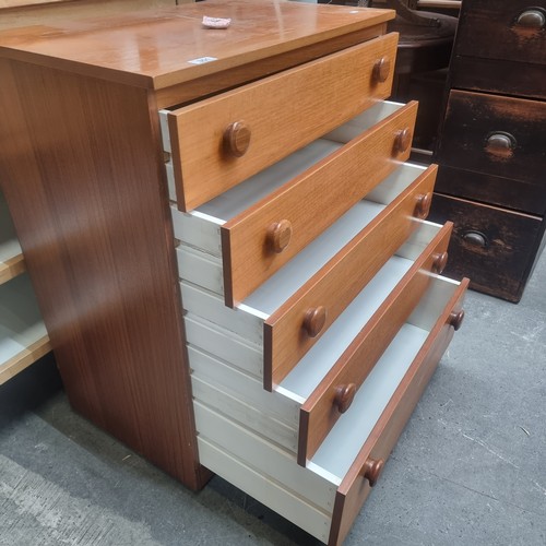 351 - A solid teak mid century modern pine chest of drawers with five drawers and large bun handles. H84cm... 