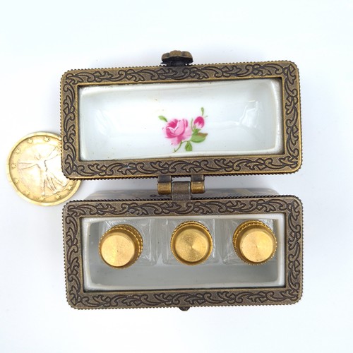 523 - A vintage French porcelain floral motif hinged casket, encased are three brass topped scent files. L... 