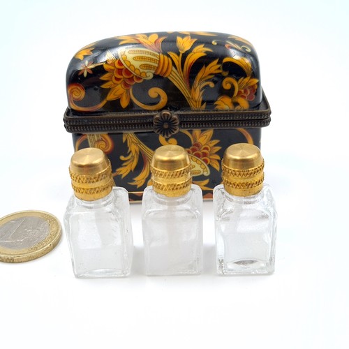 523 - A vintage French porcelain floral motif hinged casket, encased are three brass topped scent files. L... 