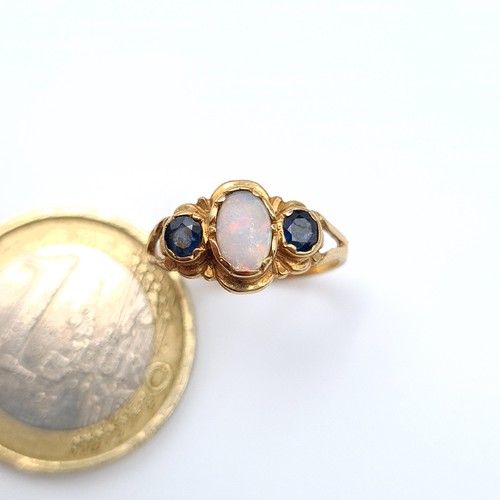 548 - An attractive 9 carat gold childs ring, featuring a beautiful central Fire Opal and Sapphire stones.... 